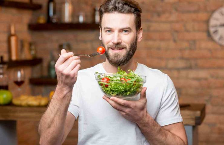 Uomo che mangia insalata