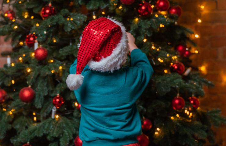 bambino vicino all'albero di Natale