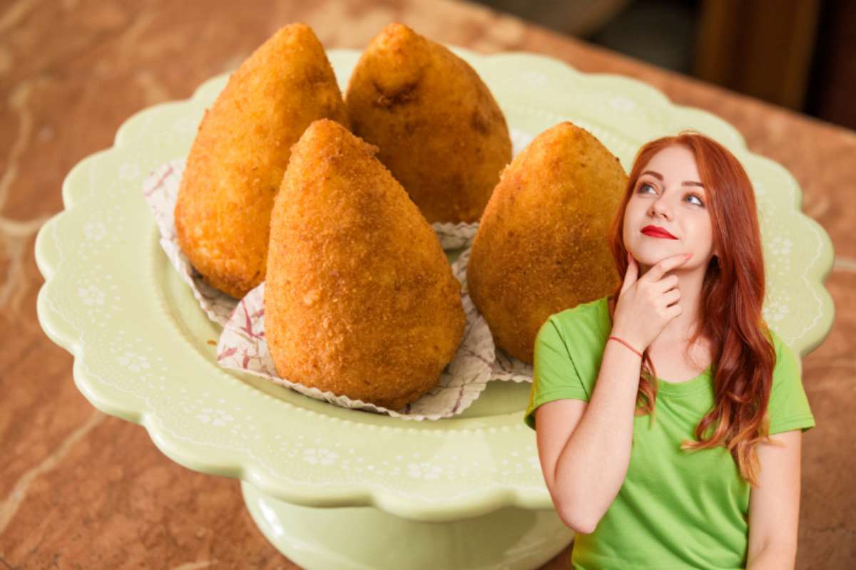 piatto di arancine con ragazza perplessa